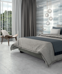 pomieszczenie wyłożone płytkami Devon Silver 60x120  z dużym łóżkiem sypialnianym oraz oknem wolnostojącym i ozdobnymi zasłonami