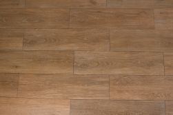 Podłoga stworzona z brązowych płytek gresowych imitujących drewno Viggo Fresno 20x75